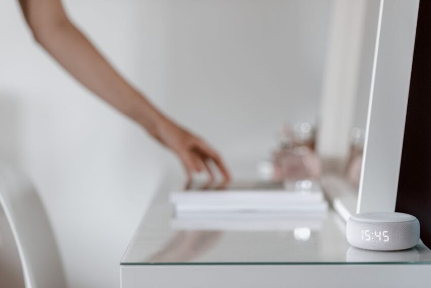 Een moderne woonkamer met slimme apparaten zoals een robotstofzuiger en smartlampen die het dagelijks leven vereenvoudigen.